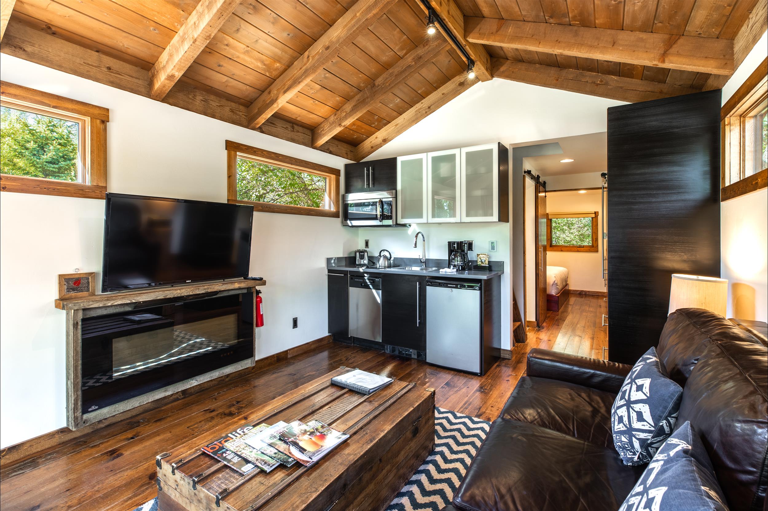 modern cabin living room with flatscreen tv and kitchenette jackson hole wy